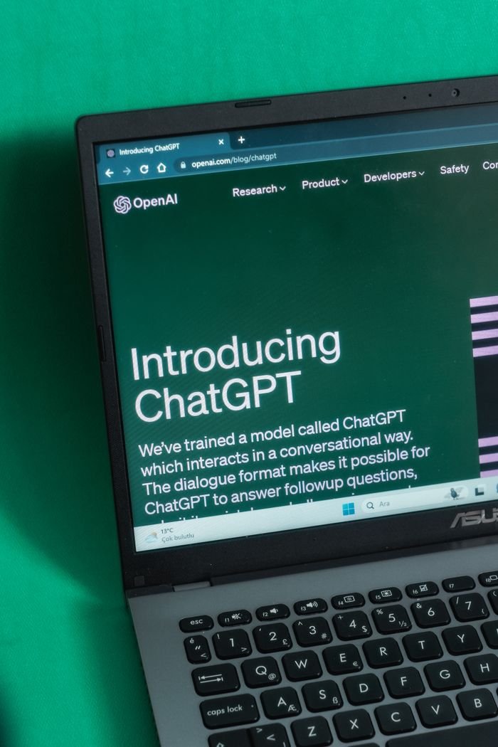Services Laptop screen displaying the introductory page of ChatGPT on OpenAI's website.