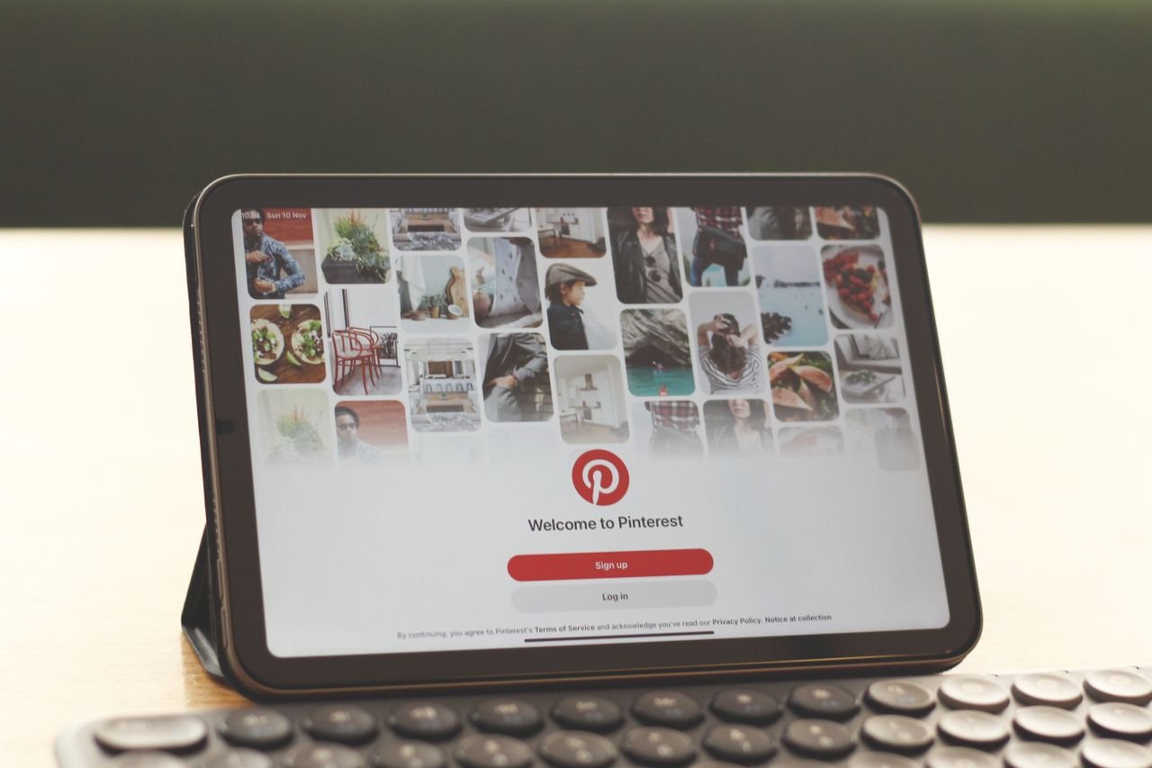 Services Tablet showing Pinterest homepage on a modern desk setup with a keyboard.